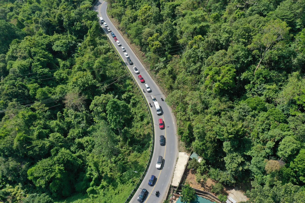 Các xe nối đuôi nhau chờ lưu thông qua điểm sạt lở trên đèo Bảo Lộc. Ảnh: VT - TS