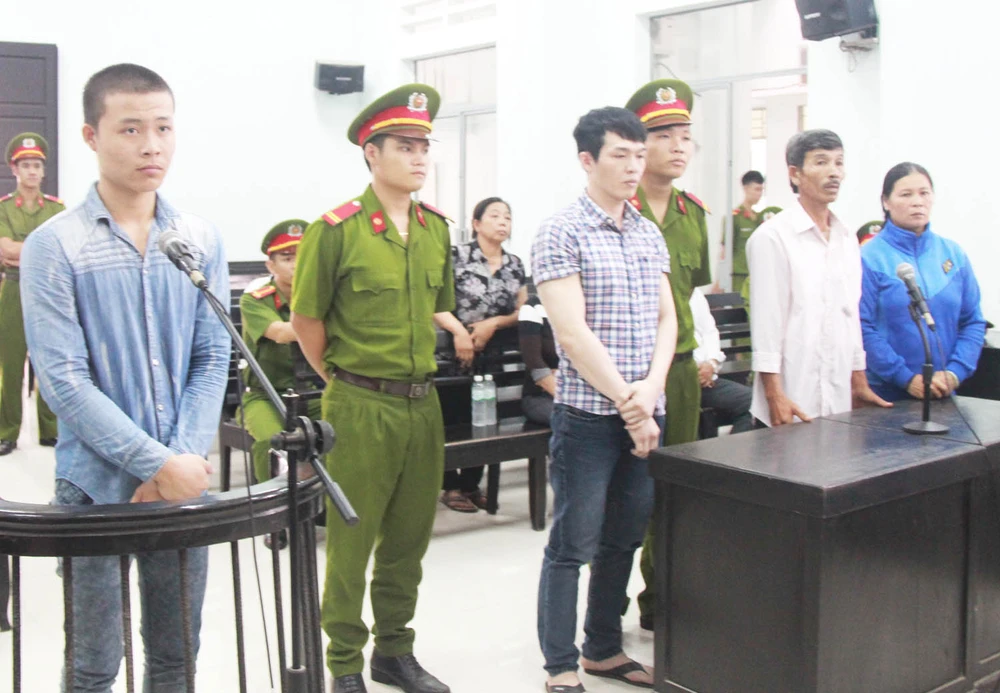 Bị cáo Lê Tấn Khỏe (bìa trái) và Lê Mnh Phát (thứ ba từ trái sang) nghe tòa tuyên án. Ảnh: TẤN LỘC