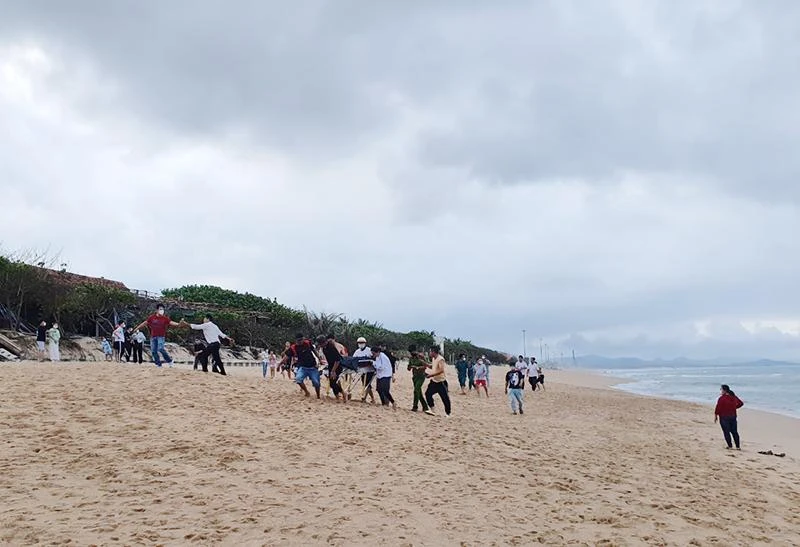 Lực lượng chức năng cùng người dân đưa các nạn nhân lên bờ. Ảnh: MK