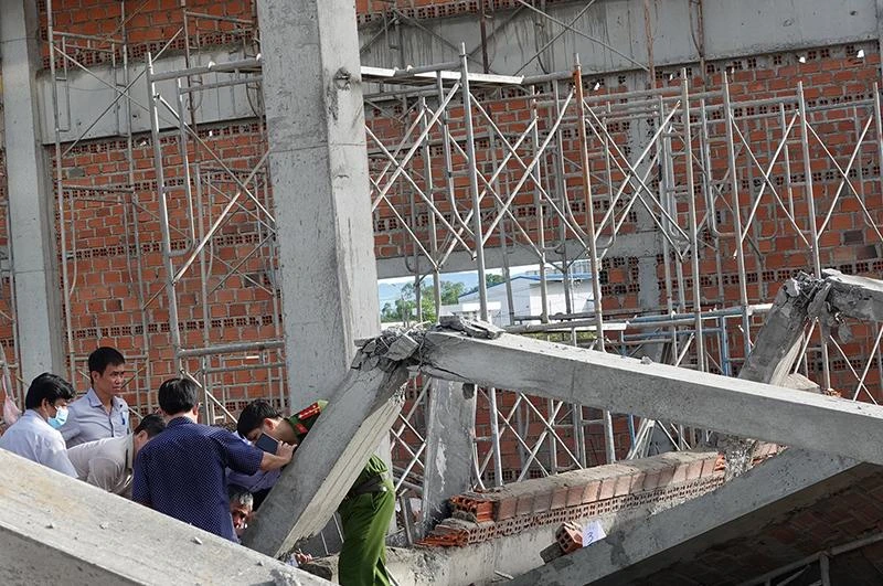 Lực lượng chức năng khám nghiệm hiện trường vụ sập tường. Ảnh: NO