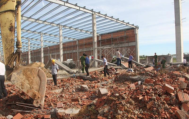 Lực lượng chức năng kiểm tra hiện trường vụ sập tường. Ảnh: NO