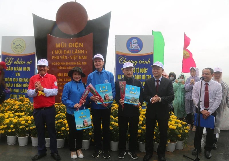 Ông Trương Hòa Bình, nguyên Ủy viên Bộ Chính trị, nguyên Phó Thủ tướng thường trực Chính phủ tặng quà cho các vị khách đầu tiên đến Phú Yên trong năm 2023. Ảnh: THANH HOÀNG