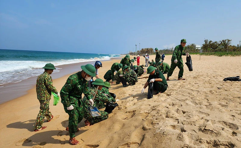 Lực lượng bộ đội thu gom dầu vón cục trên bãi biển Tuy Hòa chiều 31-3. Ảnh: NL