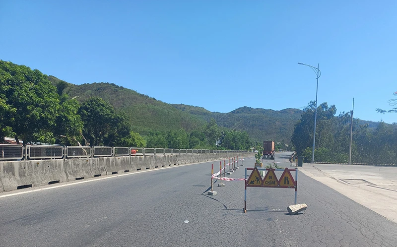 Rào chắn xung quanh hố sâu giữa mặt đường quốc lộ 1. Ảnh: VŨ XUÂN