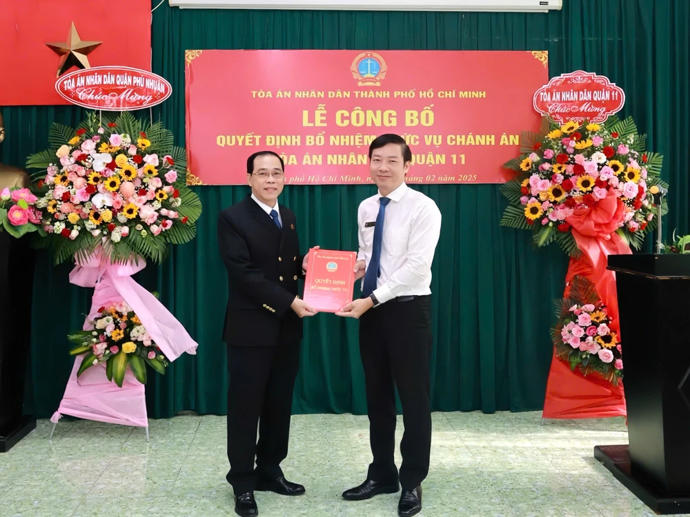 Ông Quách Hữu Thái, Phó Chánh án TAND TP.HCM trao quyết định điều động và bổ nhiệm chức vụ Chánh án TAND quận 11 cho ông Nguyễn Thanh Sang. Ảnh: THẢO HIỀN.