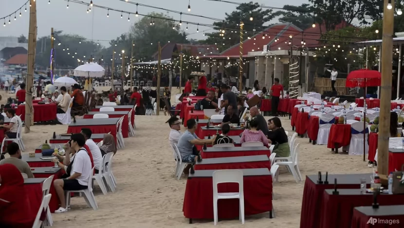 Khách du lịch ngồi tại một nhà hàng trên bãi biển Jimbaran ở đảo Bali (Indonesia) ngày 12-11. Ảnh: AP