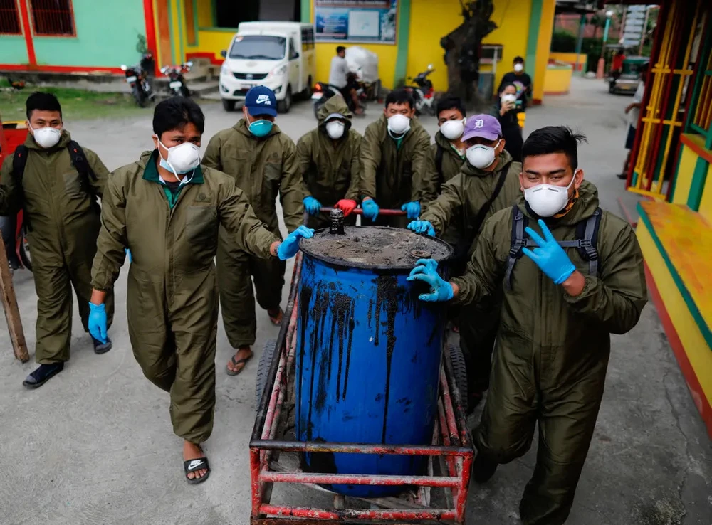 Nhân viên chính quyền thu gom chất thải dầu ở thị trấn Pola. Ảnh: EPA