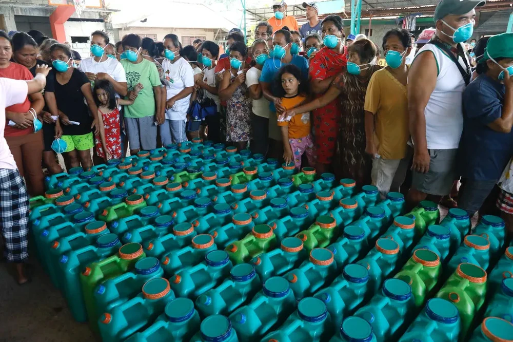 Người dân thị trấn Pola nhận nước uống. Ảnh: EPA