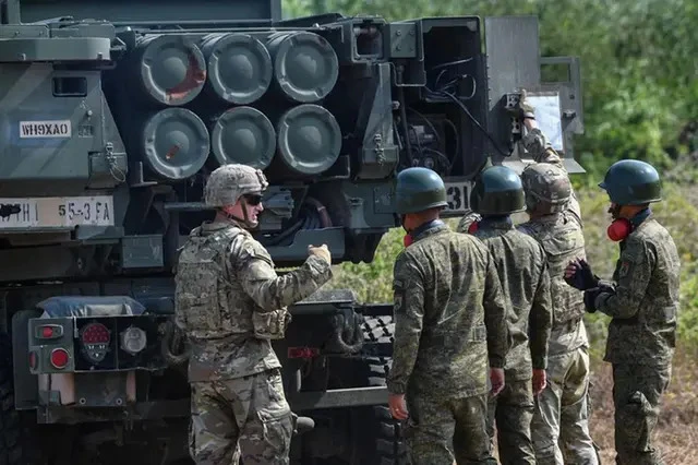 Binh sĩ Mỹ (trái) giới thiệu cho các binh sĩ Philippines về Hệ thống pháo binh cơ động cao (HIMARS) vào tháng 3-2023. Ảnh: AFP