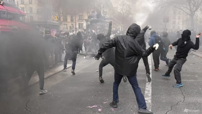 Người biểu tình ném đá vào lực lượng cảnh sát trong một cuộc biểu tình vào ngày 6-4 tại Paris. Ảnh AP