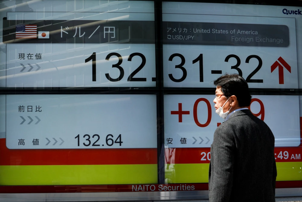 Người dân Nhật quan sát tỉ giá hối đoái giữa đồng yen Nhật và USD trên bảng điện ở thủ đô Tokyo (Nhật) ngày 20-3. Ảnh: REUTERS