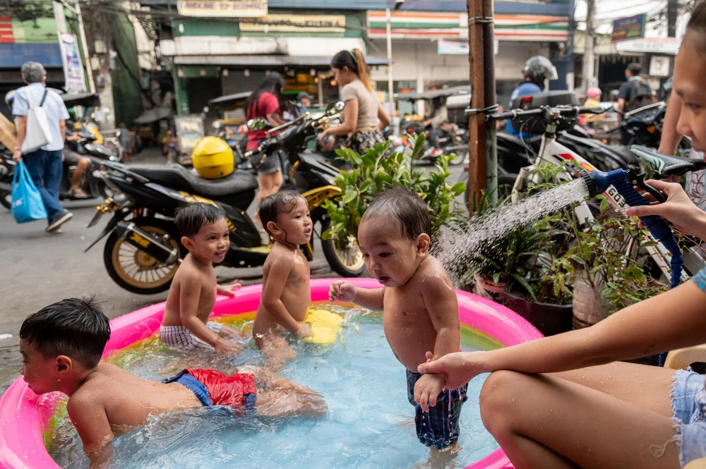 Trẻ em chơi trong một phao bơi bên cạnh một con phố ở Manila (Philippines) hồi tháng 3. Ảnh: REUTERS