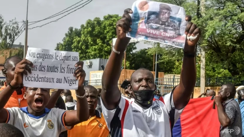 Người biểu tình ở thủ đô Niamey (Niger) giơ cao tấm biển có nội dung “Chúng tôi yêu cầu tất cả các lực lượng phương Tây rút khỏi Niger”, hôm 21-7. Ảnh: AFP