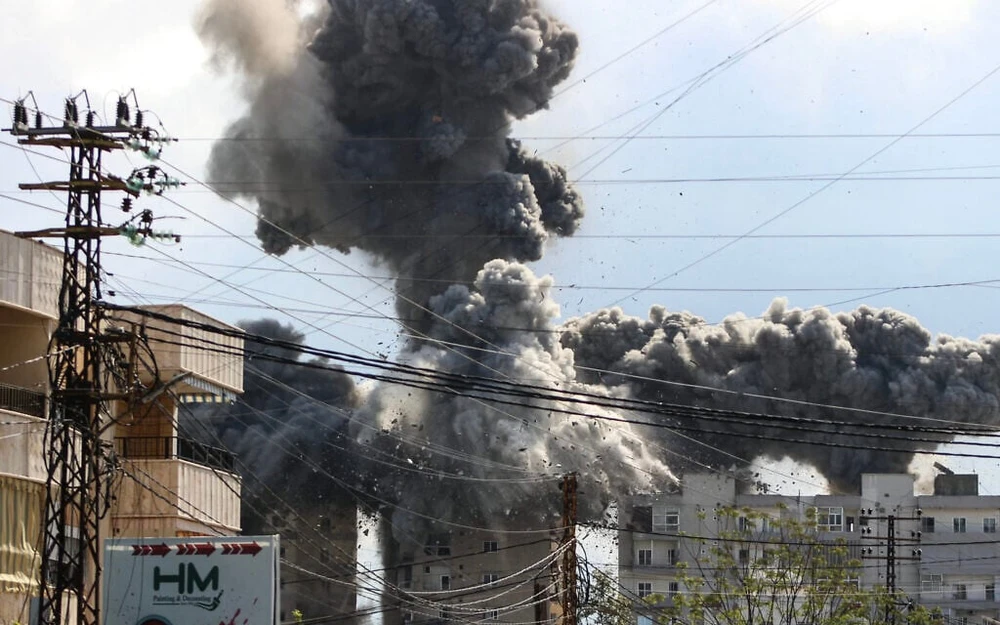 Khói và mảnh vỡ bốc lên sau khi một tòa nhà bị trúng bom trong cuộc không kích của Israel ở khu vực Abbasiyeh, ngoại ô TP Tyre (Lebanon) ngày 8-4. Ảnh: Kawnat HAJU / AFP