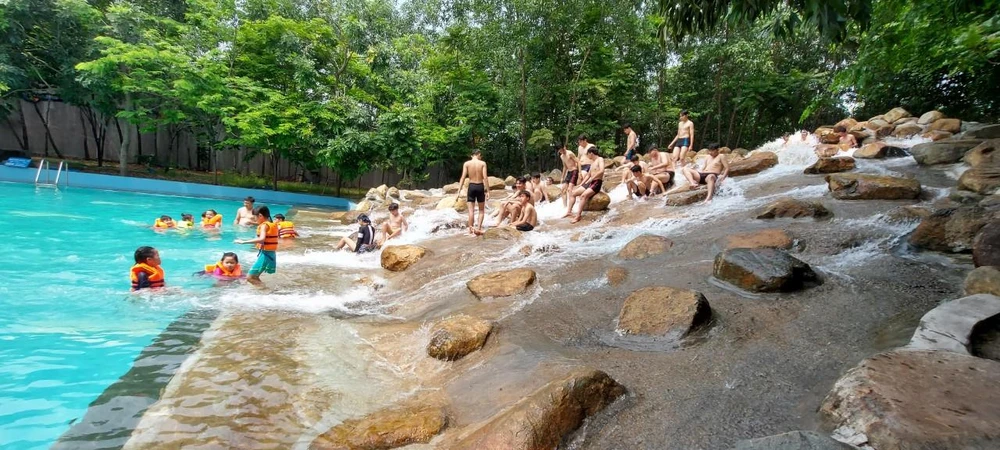 Các bạn trẻ thích thú trên suôi nước nhân tạo đổ thẳng xuống hồ bơi.