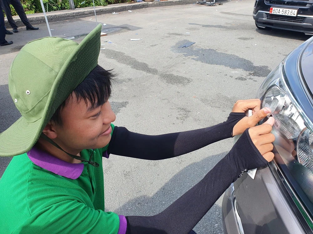 Nhân viên VEC dán thẻ ETC cho các xe qua trạm