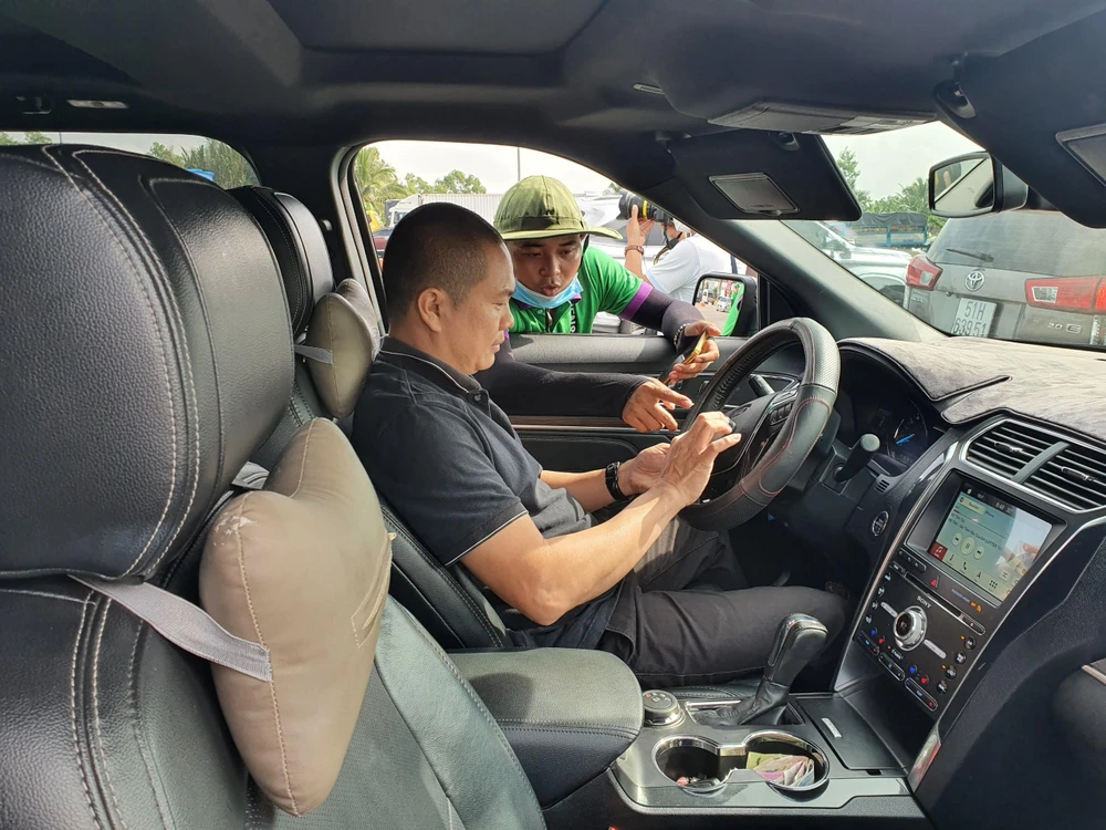 Nhân viên VEC đang hướng dẫn tài xế cài đặt tài khoản