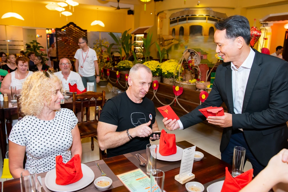 Khách du lịch quốc tế trải nghiệm văn hóa Tết truyền thống của người Việt Nam trong dịp Tết Nguyên đán 2024. Ảnh: THU TRINH