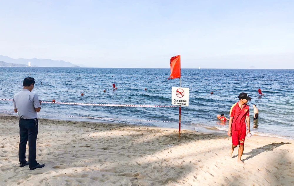 Ban quản lý vịnh Nha Trang giăng dây, cắm biển cảnh báo vị trí sà lan bị vùi lấp. Ảnh: XUÂN HOÁT