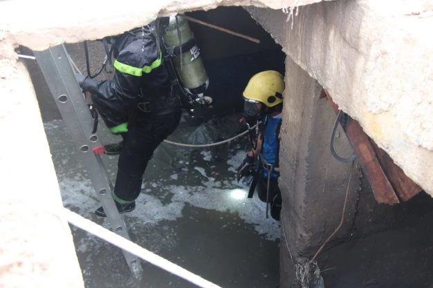 Người nhái xuống cống để tìm kiếm cháu bé - Ảnh: Bá Sơn