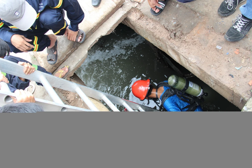 Người nhái xuống cống để tìm kiếm nạn nhân - Ảnh: Bá Sơn