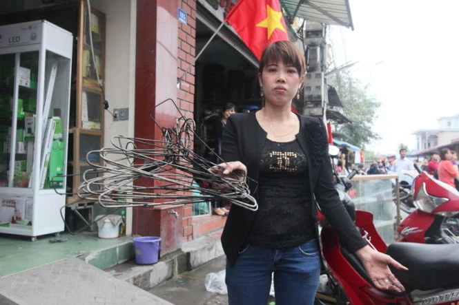 Chị Nguyễn Thị Hạnh (tiểu thương trong chợ Kinh Môn) giữ lại được vài móc quần áo còn sót lại - Ảnh: Tiến Thắng