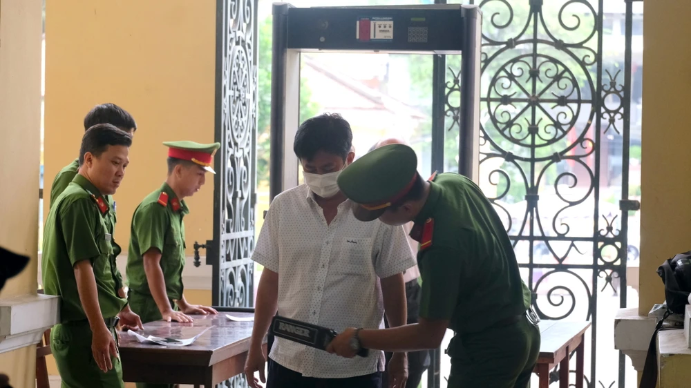 Những người tham dự phiên xét xử đều được kiểm tra an ninh trước khi vào phòng xét xử. ẢNH: SONG MAI
