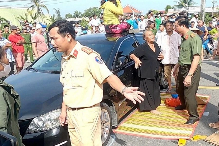 Công an đến khuyên bà Dung chấm dứt hành động chặn quốc lộ nhưng bà và các con không nghe theo, khiến quốc lộ 1A ùn tắc kéo dài 2 giờ đồng hồ hôm 24-11-2020. Ảnh: CTV