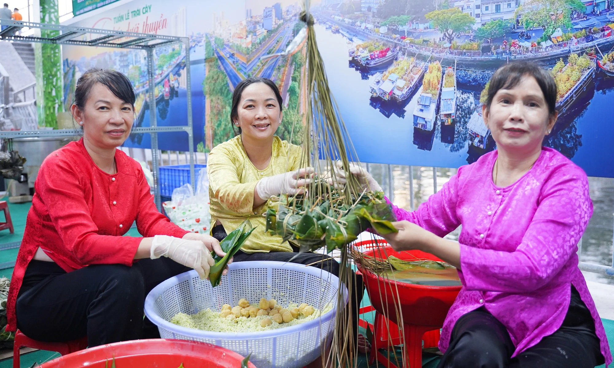 Cô Ngọc Minh, ngụ phường 5, quận 8, TP.HCM (phía phải), là đời thứ tư giữ nghề gói bánh ú truyền thống từ gia đình. Cô rất vui khi có mặt tại sự kiện. Tuan-le-trai-cay (2).jpg