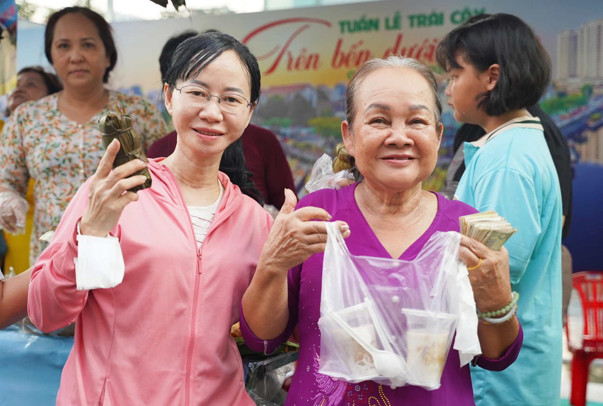 Cô Lê Thị Hường, 72 tuổi, quê Tiền Giang (áo tím), phấn khởi khi được nhiều bà con mua và khen bánh do nhà làm ngon, mang đậm vị miền Tây. Tuan-le-trai-cay (21).jpg