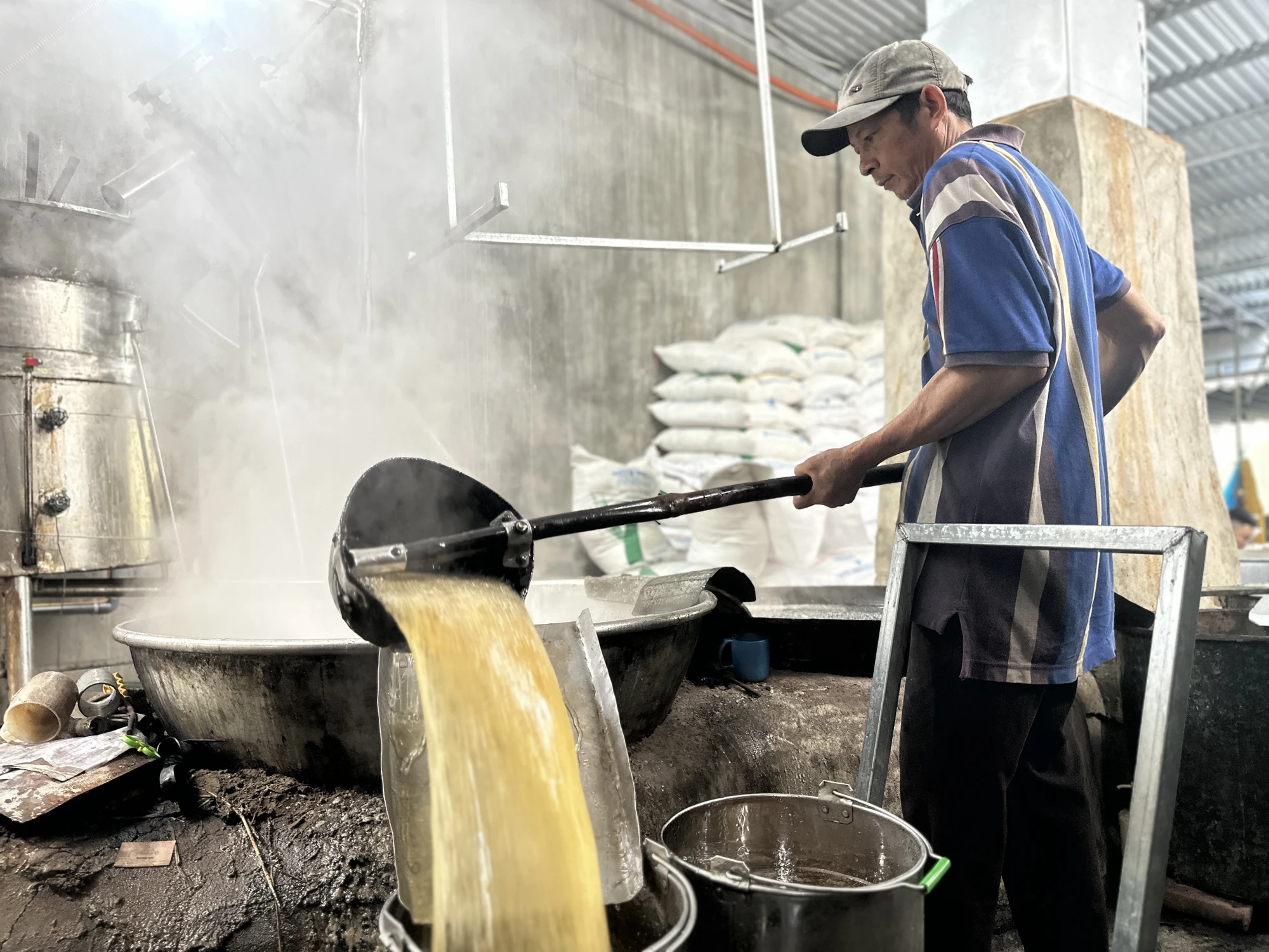 “Để đường kết tinh đều, đẹp cần 2 bí quyết là dùng vỉ chỉ và yếu tố tĩnh. Vỉ chỉ là 2 vỉ tre được cố định bởi khung sắt, chỉ được luồn qua vỉ tre sau đó bỏ vào thùng sắt rồi đổ nước đường vào thùng. Vỉ chỉ sẽ giúp đường phèn kết tinh và bám vào thành từng mảng như đá thạch anh. Bí quyết thứ hai là thùng chứa nước đường phải đặt ở nơi bằng phẳng. Suốt quá trình chờ đường kết tinh không được làm thùng rung động” - bà Lắm nói. lang-nghe-duong-phen-do-lua-suot-tram-nam-o-quang-ngai-22.JPG