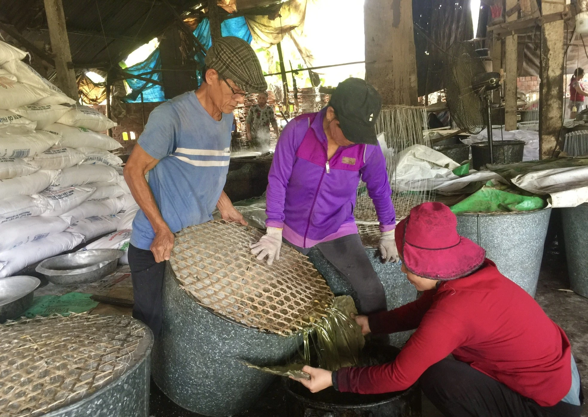 Ông Đồng Văn Chính (áo xanh) là người đã kế nghiệp làm đường phèn từ cha mình. Ông cho hay đây là nghề truyền thống của gia đình, có từ thời ông cố, đến nay đã trăm năm. lang-nghe-duong-phen-do-lua-suot-tram-nam-o-quang-ngai-32.jpg