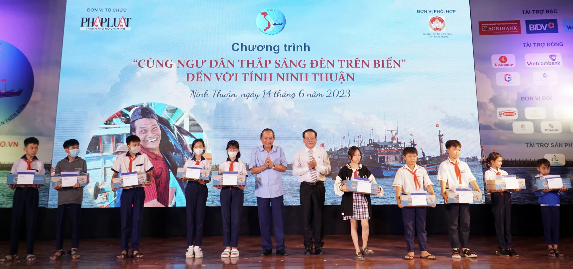 Ông Trương Hòa Bình, nguyên Phó Thủ tướng thường trực và ông Mai Ngọc Phước, Tổng biên tập báo Pháp Luật TP.HCM, trao tặng các suất học bổng cho các em học sinh. Ảnh: NHẬT DIỄM