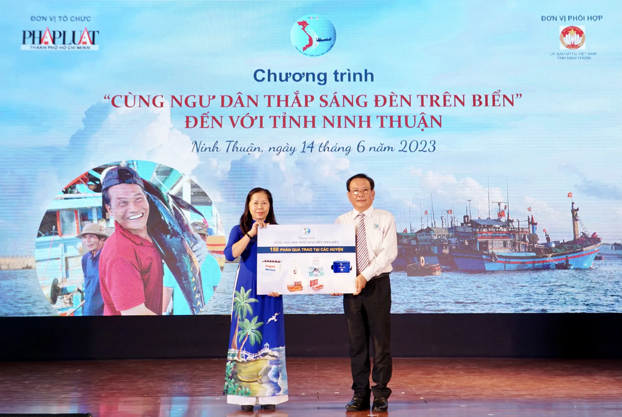 Tổng biên tập báo Pháp Luật TP.HCM trao bảng tượng trưng 150 phần quà của các ngư dân còn lại cho bà Phạm Thị Bích Hà, Phó Chủ tịch Ủy ban MTTQ Việt Nam tỉnh Ninh Thuận. Ảnh: NHẬT DIỄM