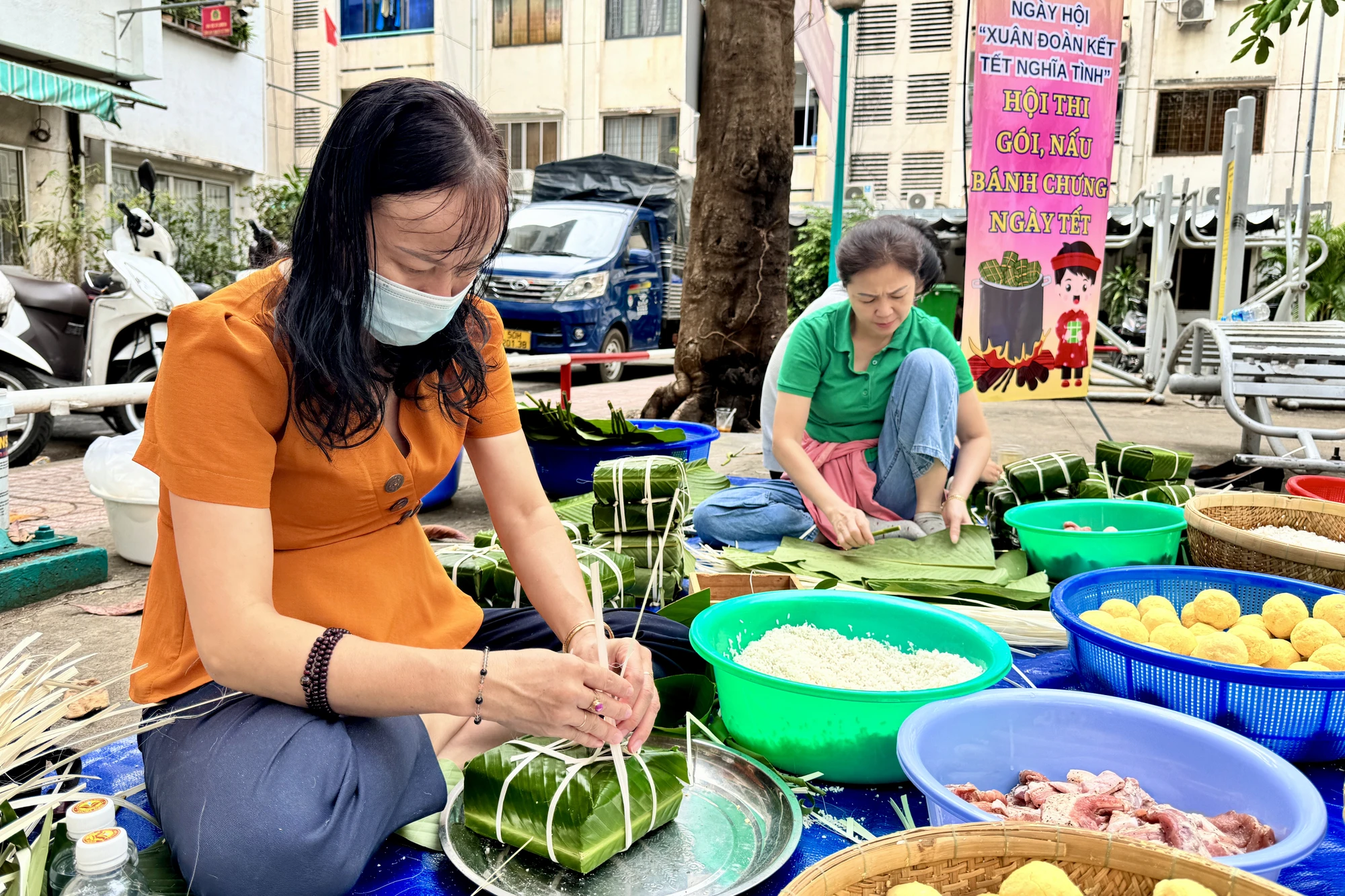 Người dân khu phố 14 (phường Nguyễn Cư Trinh, quận 1) rộn ràng thi gói bánh chưng để trao cho hộ nghèo, hộ khó khăn. Ảnh: BẢO PHƯƠNG IMG_3251.JPG