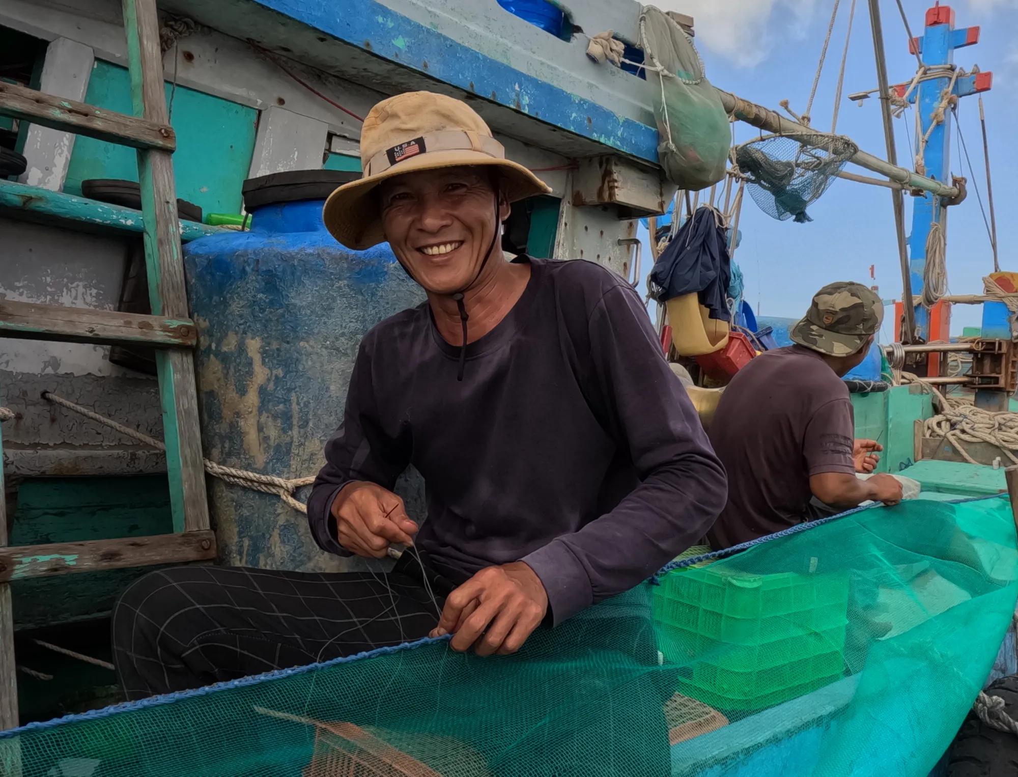 Ngư dân đan lưới chuẩn bị ra khơi. Ảnh: TK