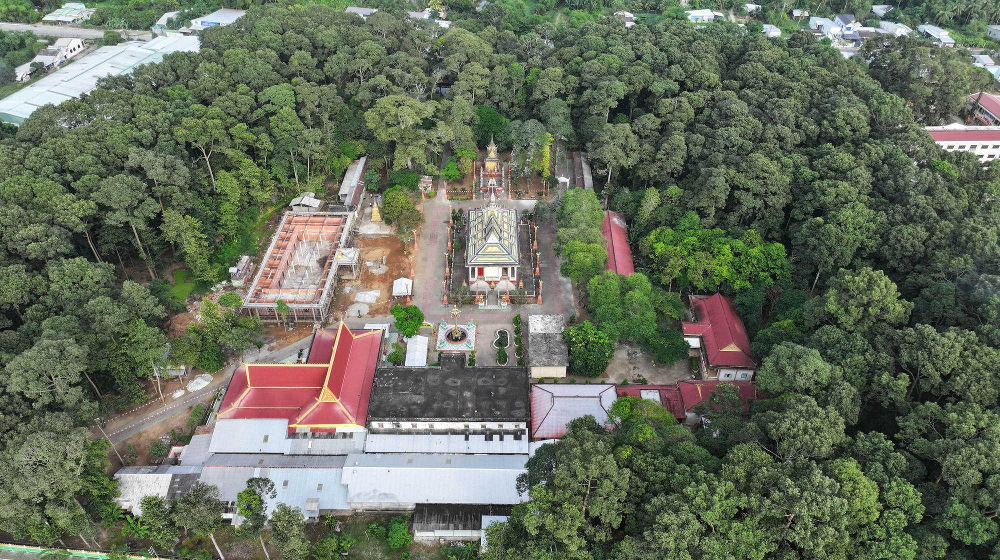 Chùa Kompong Chrây được bao quanh bởi một hàng cây cổ thụ rợp bóng. Ảnh chụp Màn hình 2025-01-16 lúc 11.27.30.png