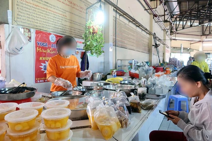 Tiểu thương chợ An Sương, quận 12, luôn đeo găng tay, khẩu trang tuân thủ vệ sinh ATTP. Ảnh: TRẦN MINH An-toan-thuc-pham-plooo.jpg