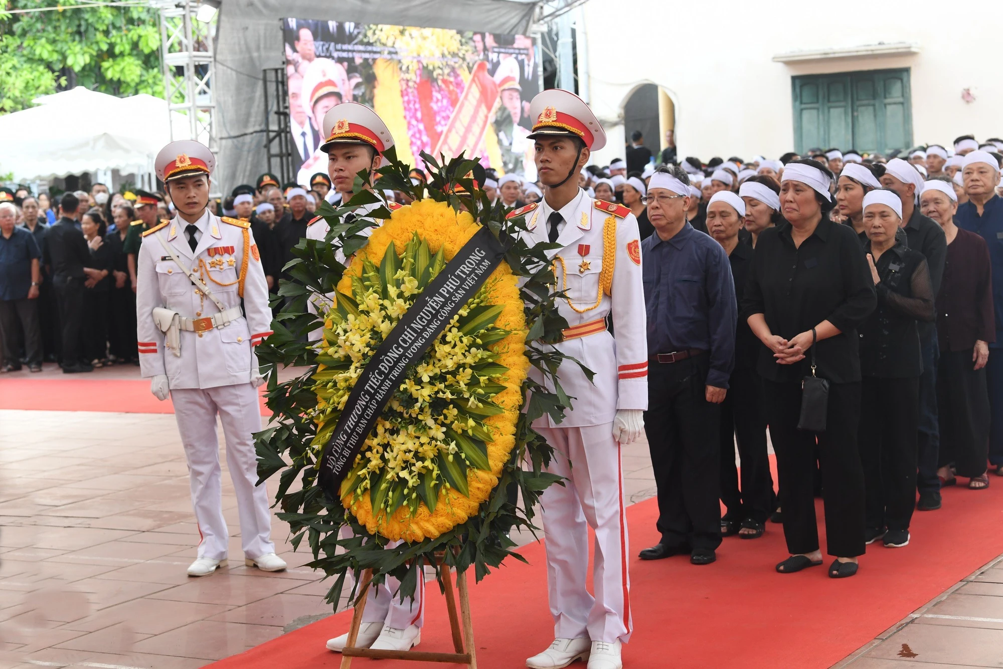 Hàng người lặng lẽ nối dài vào làng Lại Đà theo hai hướng từ cổng chính và hướng từ đê Tả Hồng vào khu vực tổ chức Lễ Quốc tang. Tinh-cam-nguoi-dan-que-huong-trong-Le-Quoc-tang-Tong-Bi-thu-Nguyen-Phu-Trong-11.jpg