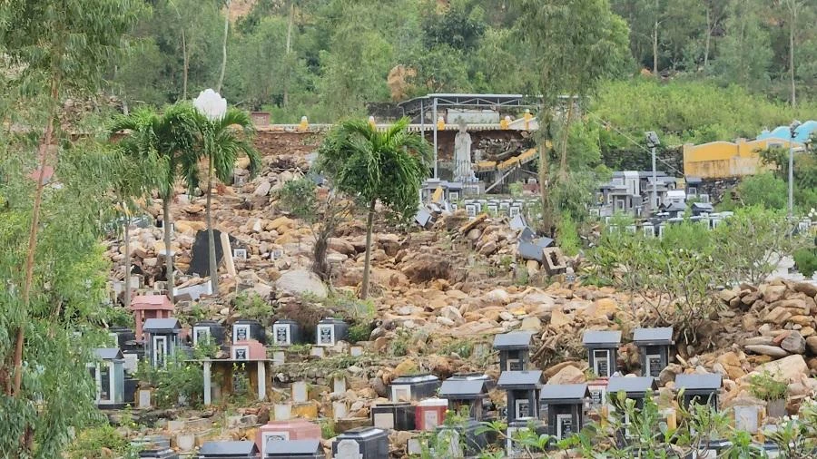 Hàng tấn đất đá đổ xuống vùi lấp và làm bật trung nhiều ngôi mộ. Ảnh: TẤN VIỆT Hàng tấn đất đá đổ xuống vùi lấp và làm bật trung nhiều ngôi mộ. Ảnh: TẤN VIỆT