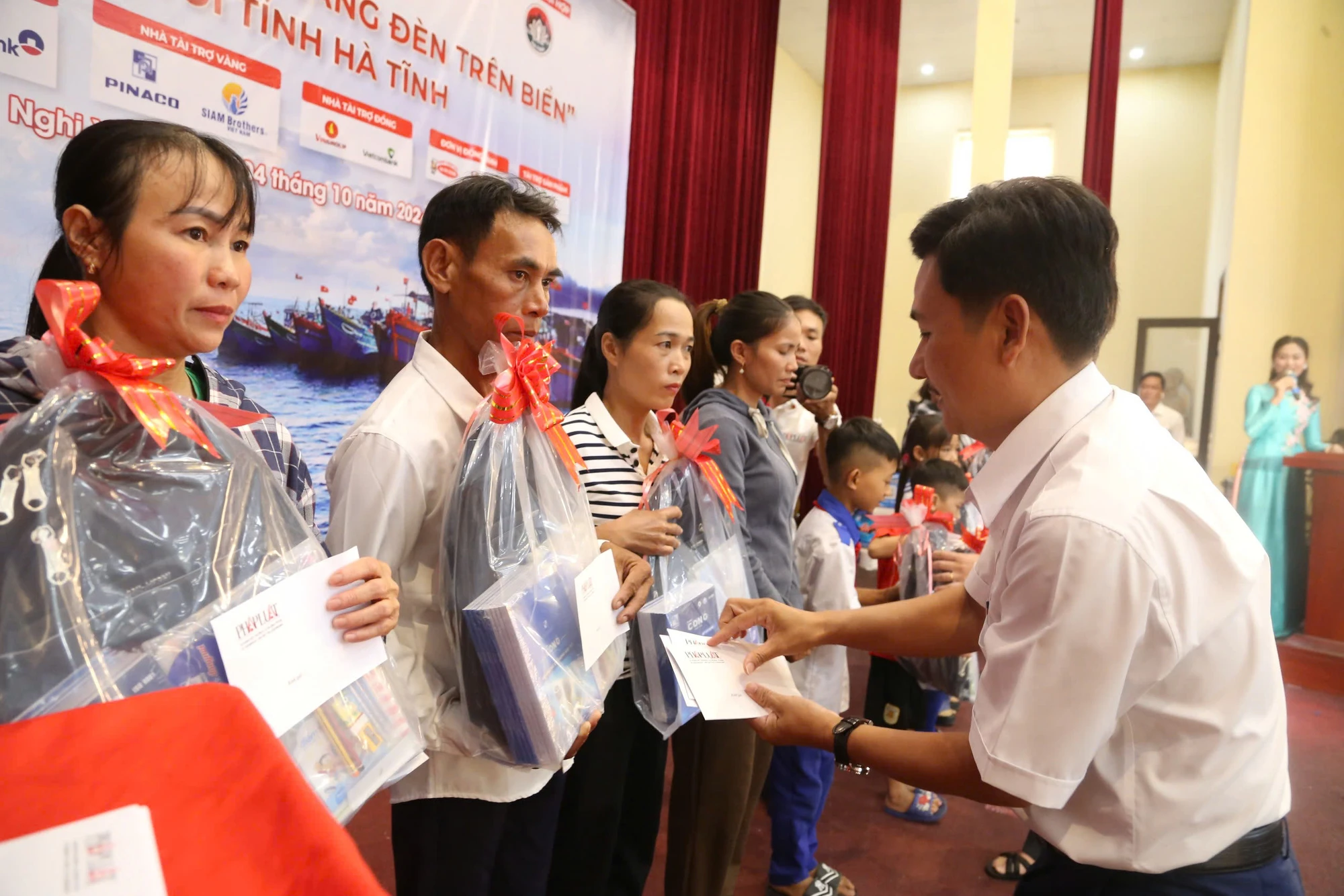 Ông Nguyễn Văn An (bên trái), Giám đốc Chi nhánh Đà Nẵng, Công ty CP Pin ắc quy miền Nam (PINACO) trao quà tặng các em học sinh là con em ngư dân Hà Tĩnh.