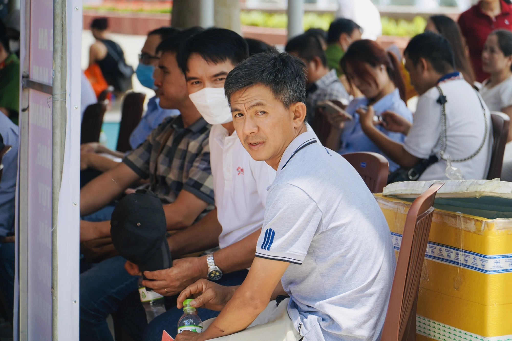 Hiểu được thời tiết oi bức của mùa hè, các chiến sĩ Công an phát tặng nước suối lạnh cho bà con. Ảnh: TRẦN MINH