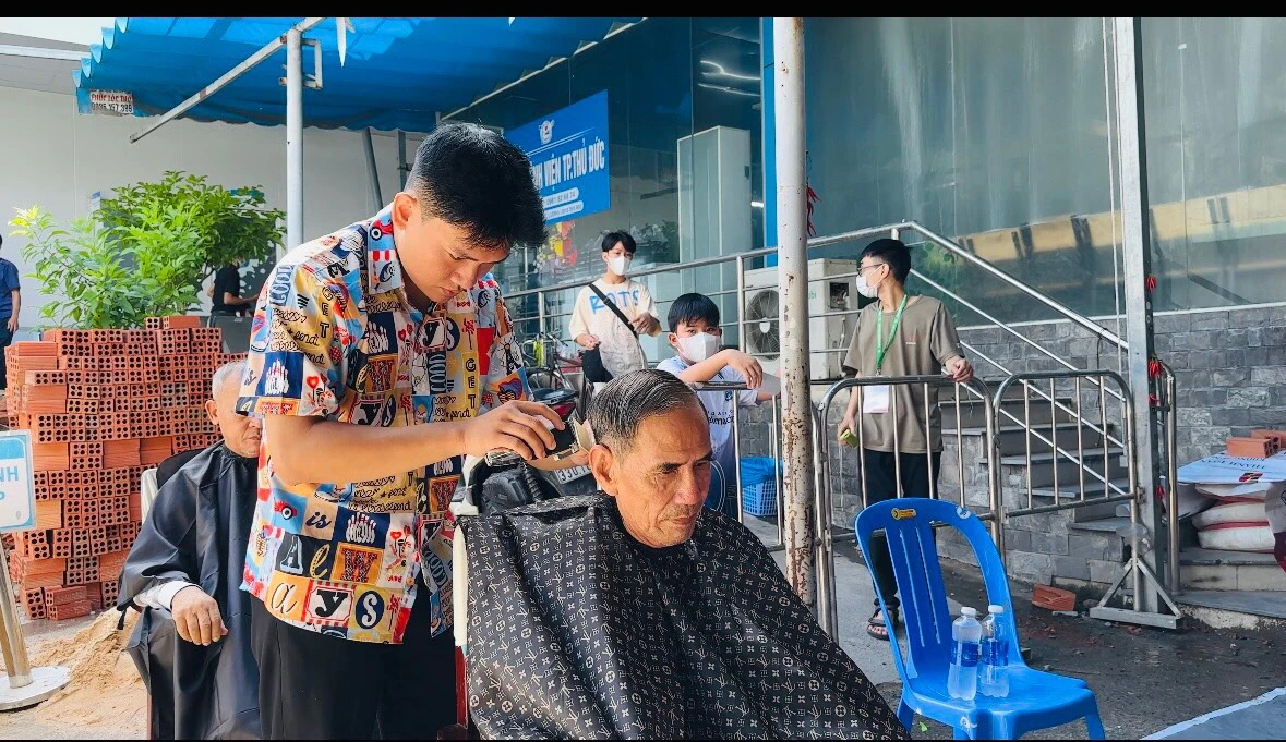 Ông Thơm và các bệnh nhân khác được trải nghiệm cắt tóc miễn phí tại phiên chợ.