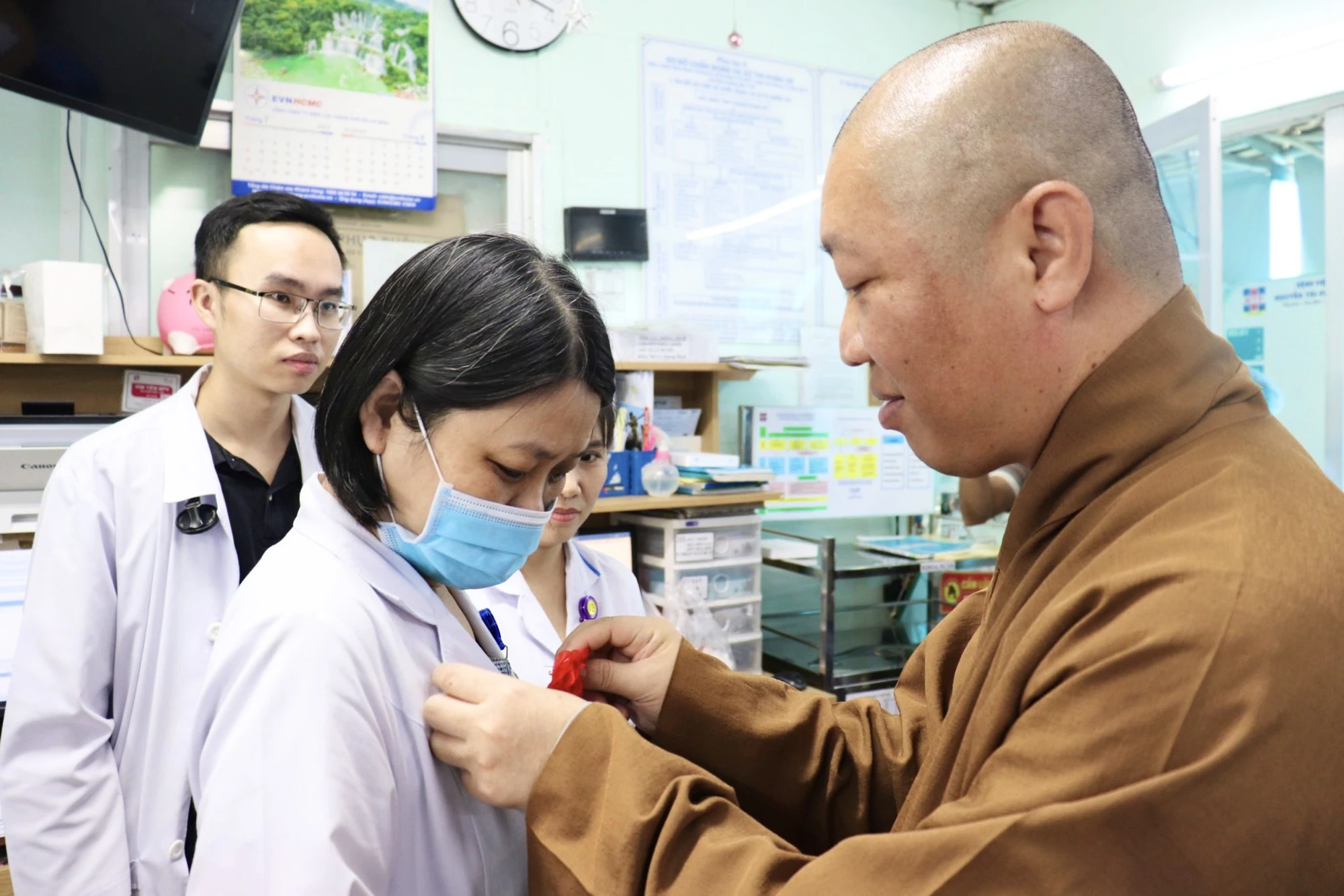 Thượng tọa Thích Thiện Thuận cài bông hồng cho các y bác sĩ. Ảnh: TRẦN MINH Thượng tọa Thích Thiện Thuận cài bông hồng cho các y bác sĩ. Ảnh: TRẦN MINH