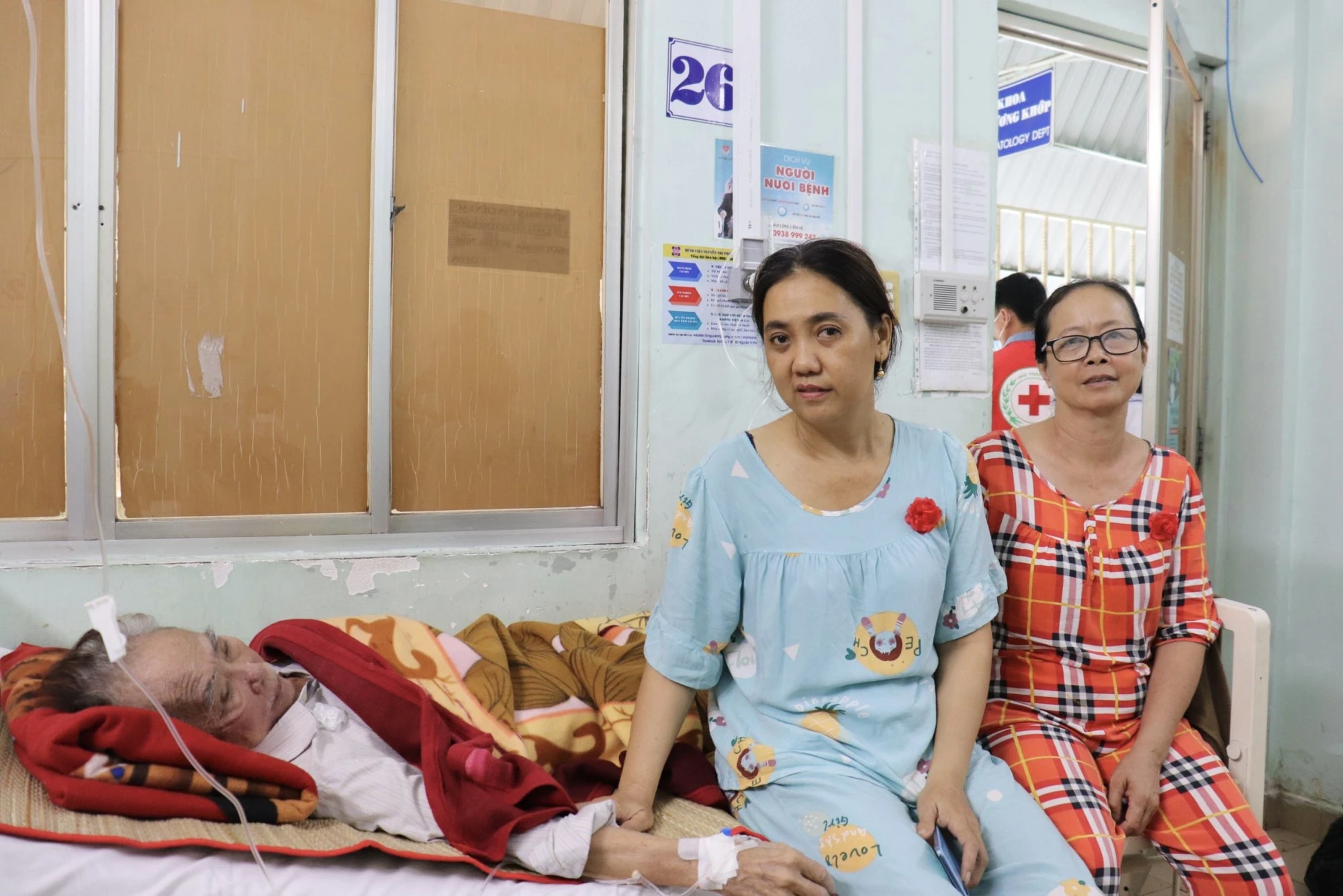 Chị Nguyễn Thị A-Rê (áo đỏ) đang cùng em gái chăm sóc ba tại BV. Ảnh: TRẦN MINH Chị Nguyễn Thị A-Rê (áo đỏ) đang cùng em gái chăm sóc ba tại BV. Ảnh: TRẦN MINH