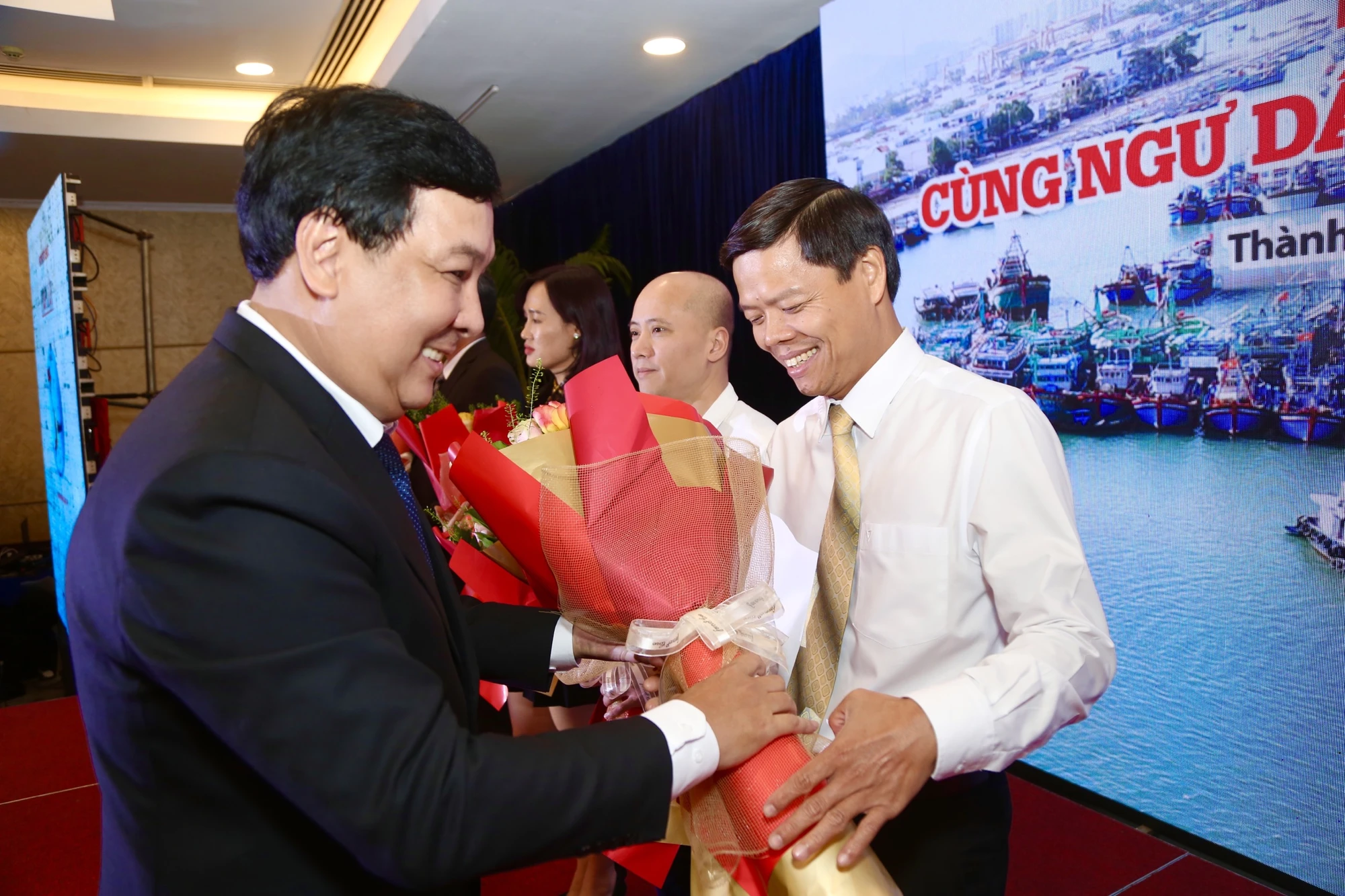 Phó Tổng biên tập báo Pháp Luật TP.HCM Nguyễn Thái Bình, Trưởng ban tổ chức chương trình “Cùng ngư dân thắp sáng đèn trên biển” trao hoa cảm ơn các nhà tài trợ đồng hành cùng chương trình. Ảnh: HOÀNG GIANG