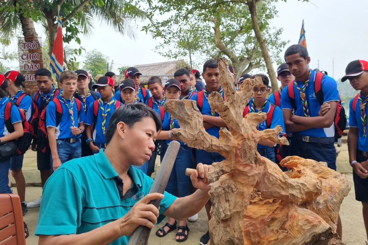 Đoàn du khách nước ngoài thích thú, tròn xoe mắt ngắm nghệ nhân mộc Kim Bồng tạc tượng. Ghé làng mộc Kim Bồng, ngắm nghệ nhân điêu khắc