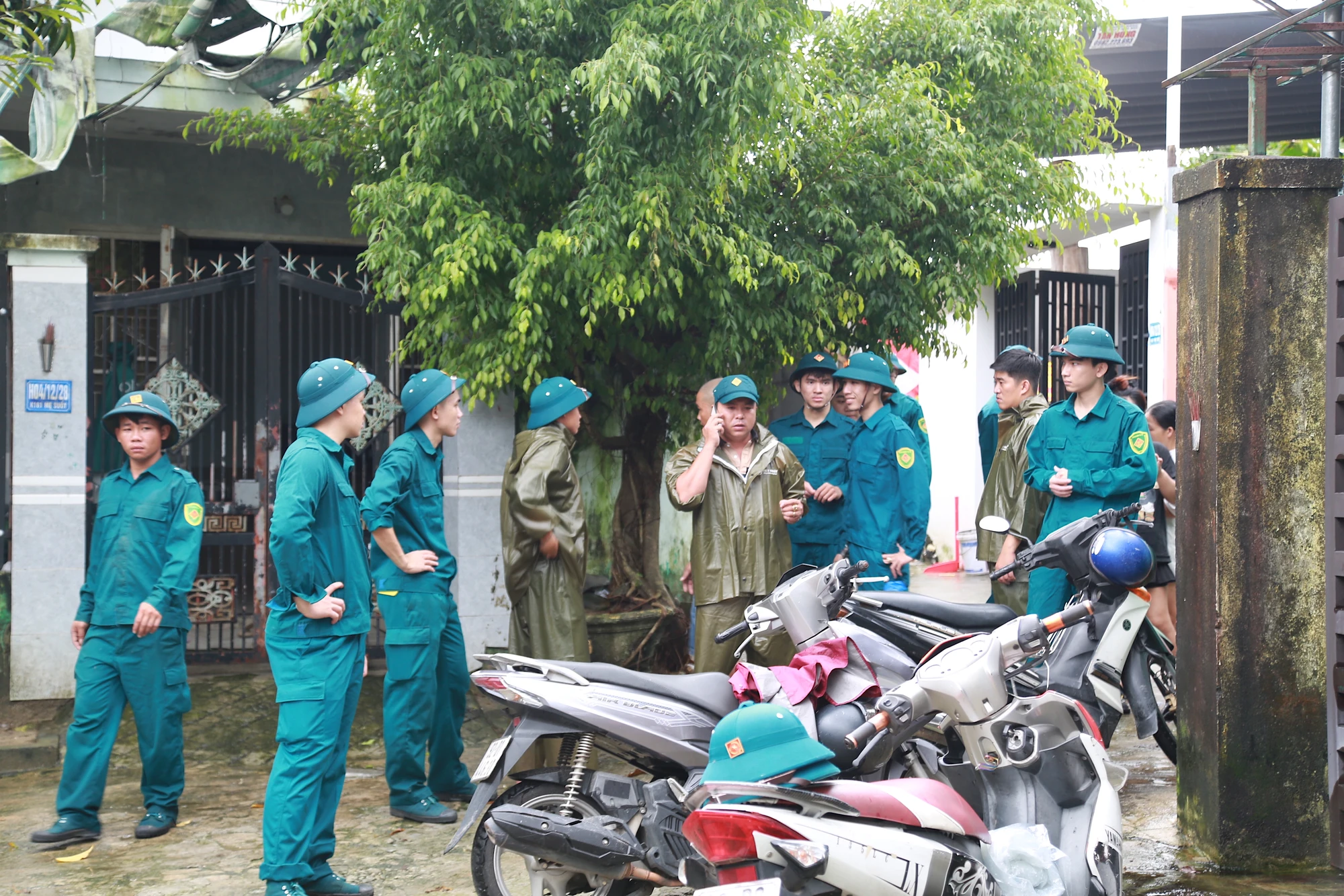 Dân quân phường Hoà khánh gõ cửa từng nhà, giúp người dân kê cao đồ đạc. Ảnh: Thanh Nhật