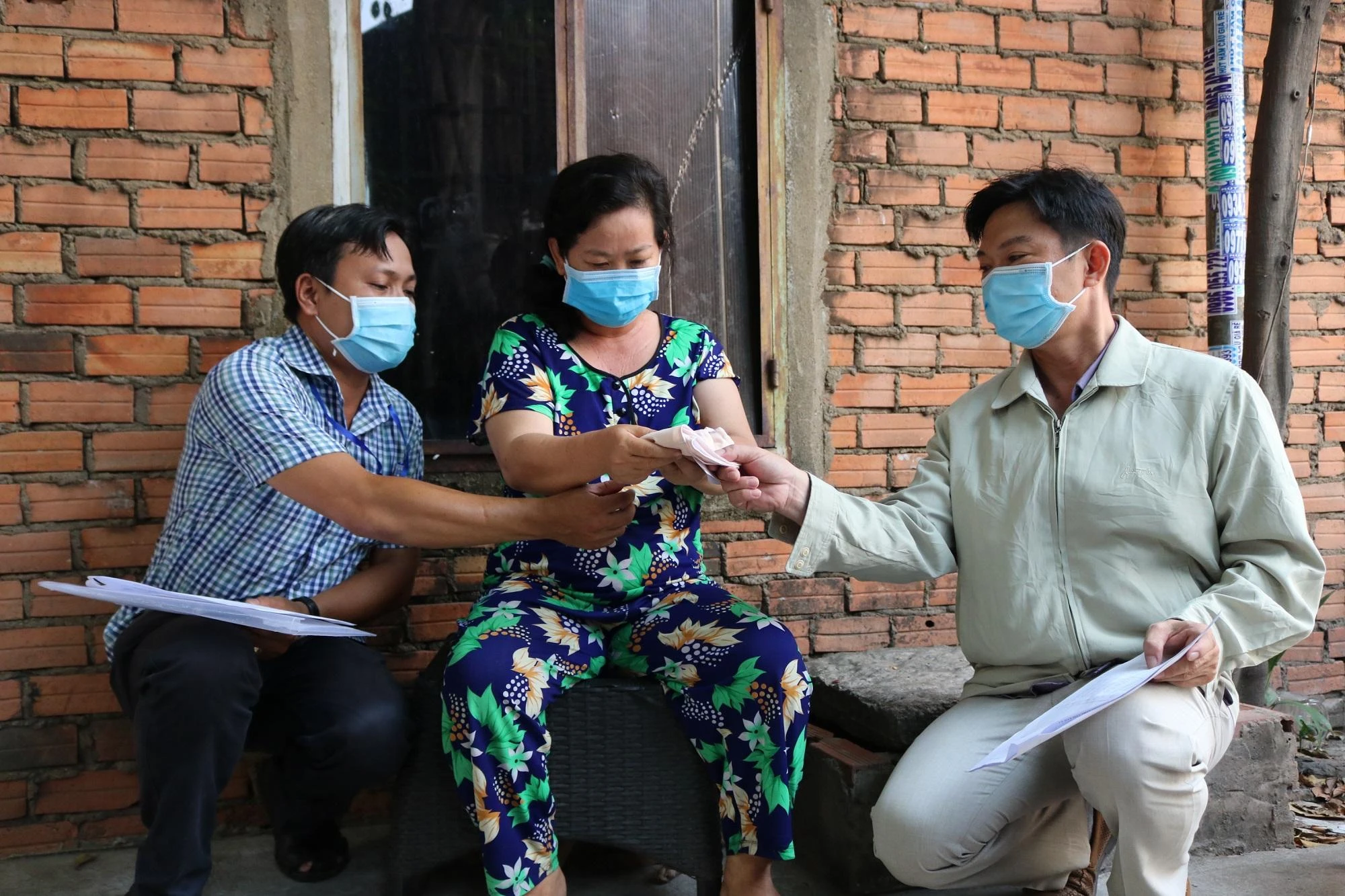 Cán bộ MTTQ phường Linh Tây cùng cán bộ khu phố chi tiền hỗ trợ cho người dân trong đợt dịch COVID-19. Ảnh: THANH TUYỀN tphcm-xoa-bo-to-dan-pho