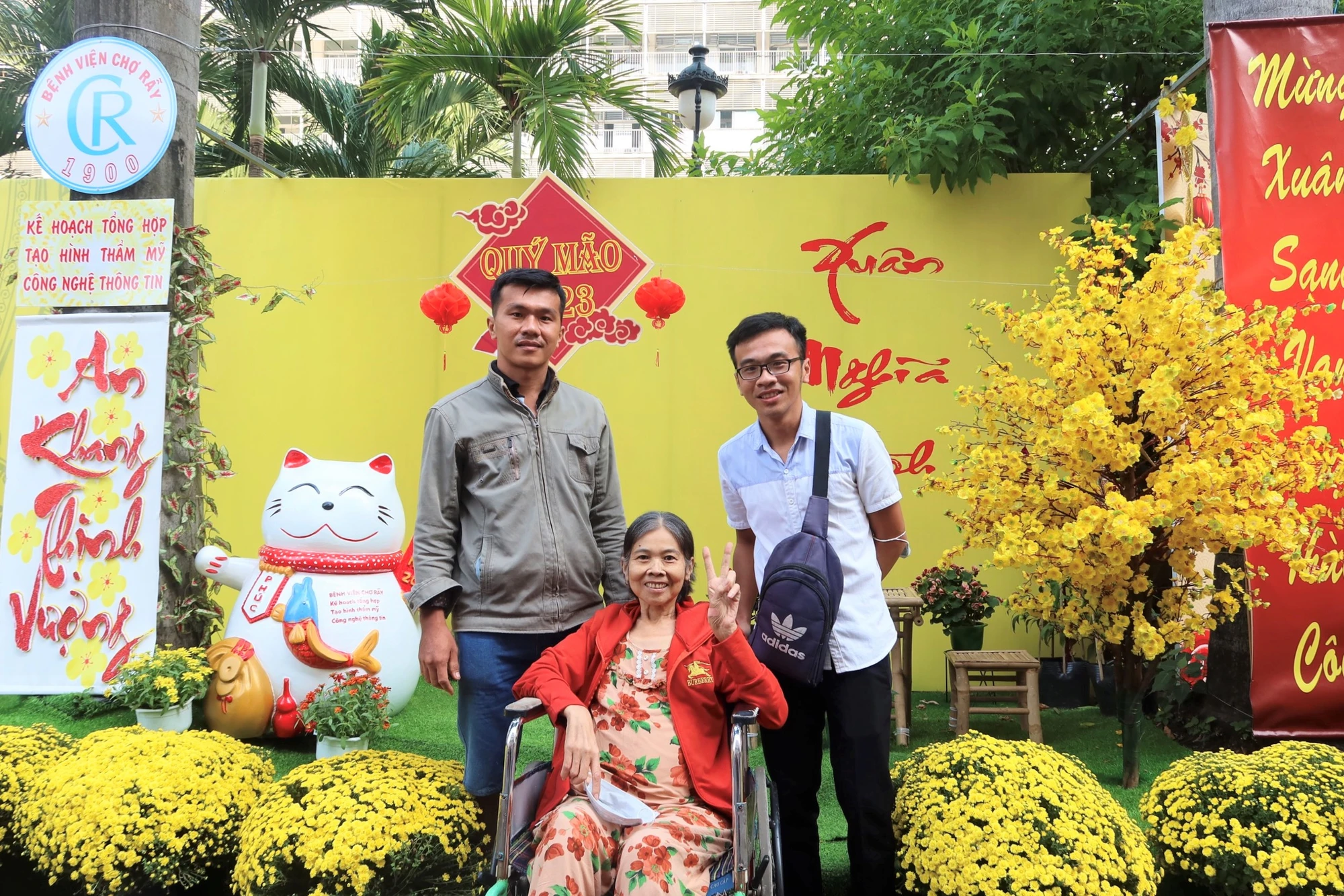 Bệnh nhân cùng thân nhân chụp ảnh kỉ niệm tại đường hoa xuân. Ảnh: TRẦN MINH
